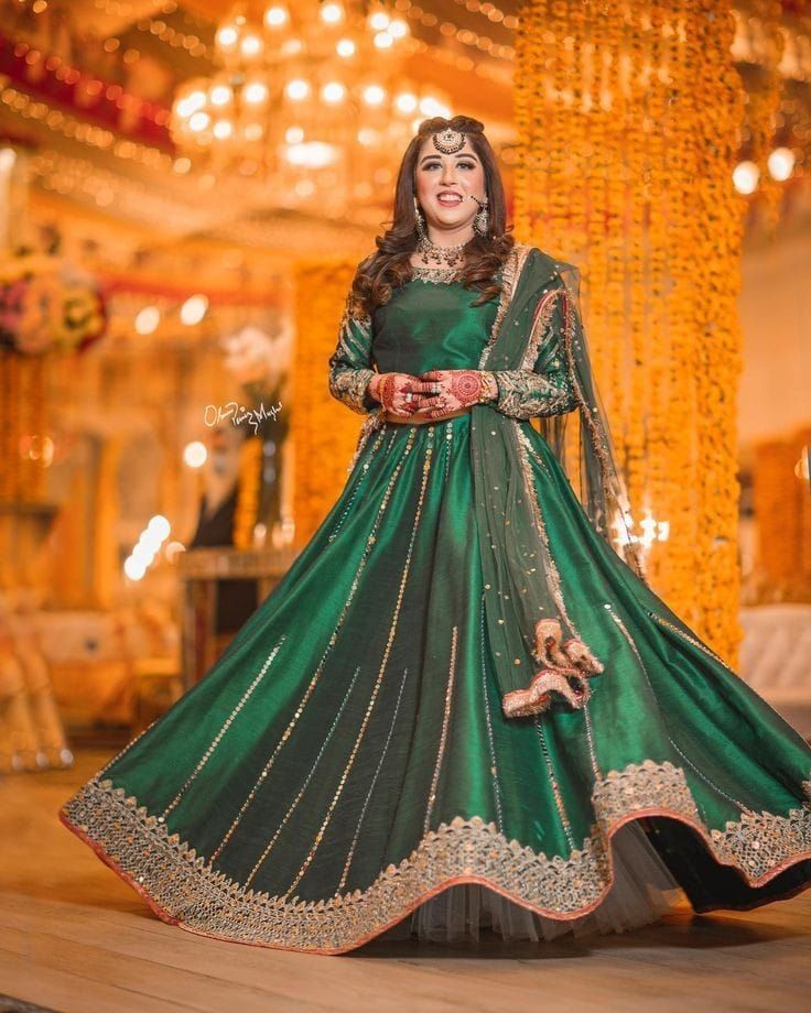 a woman in a green and gold lehenga