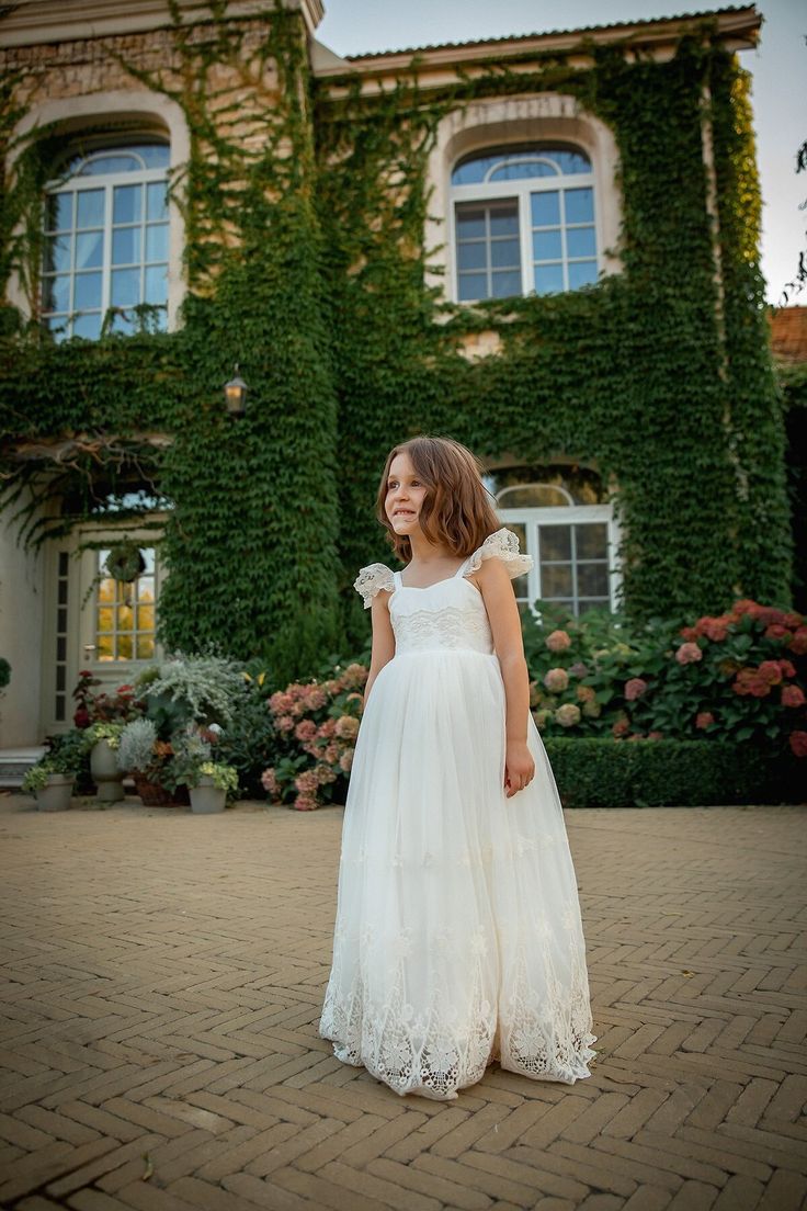 This gorgeous dress features a very elegant, yet simple, style!  The dress is completely lined and adorned with lace. Back elastic and bow for ease and comfort!  A full tulle skirt with gown length. The ivory color adds a bit of vintage charm. This gown is fully lined in 100% cotton for a comfortable feel. We know that tulle can be scratchy, and kids don't like scratchy dresses! We're here to provide you with the perfect combination of elegance and comfort for your next formal occasion. This gown is stunning for flower girls, junior bridesmaids, baptisms, dedications, portraits, blessing ceremonies, and much more! DELIVERY Dresses are made to order, so they will be ready for delivery within 5-7 working days (or less). In each case, I will tell you the exact date of readiness for delivery. Elegant First Communion Ball Gown With Lace Bodice, Elegant Lace Bodice Dress For First Communion, Elegant First Communion Princess Dress With Lace Sleeves, First Communion Lace Ball Gown With Tulle Skirt, First Communion Ball Gown With Lace And Tulle, Elegant Princess Dress With Lace Sleeves For First Communion, Lace Ball Gown With Tulle Skirt For First Communion, First Communion Dresses With Fitted Bodice, First Communion Princess Dress With Lace Bodice