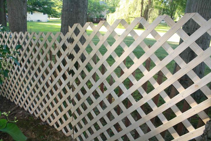 a wooden fence in front of some trees