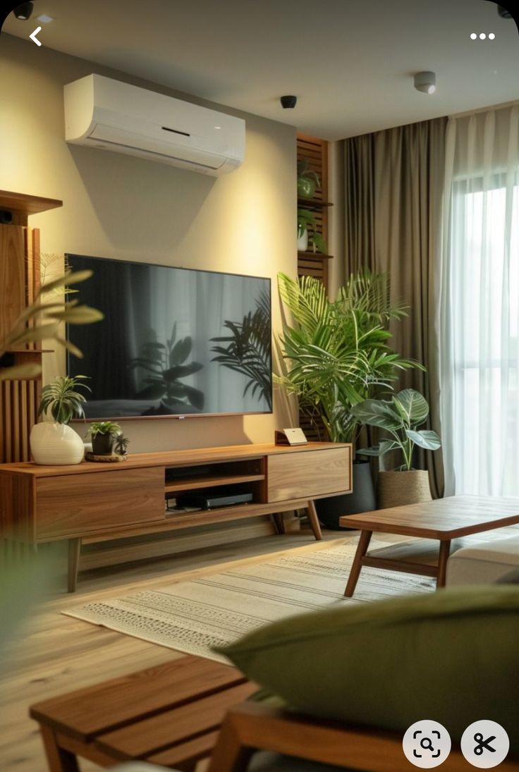 a living room filled with furniture and a flat screen tv sitting on top of a wooden entertainment center