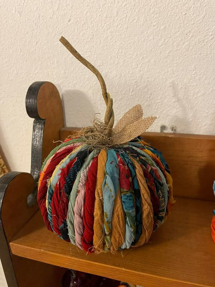 a wooden shelf topped with a multicolored pumpkin