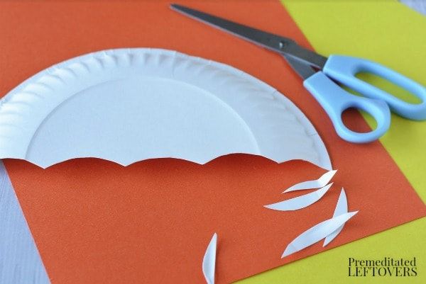 paper plate cut out to look like an umbrella with scissors on the table next to it