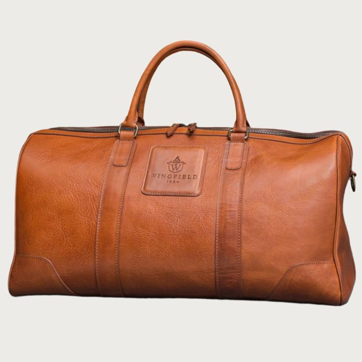 DESCRIPTION: Crafted with premium vegetable tanned leather and premium old brass hardware, the WESTFIELD LEATHER DUFFEL BAG combines durability and style. Perfect for business trips or weekend getaways, this leather duffle offers both form and function for the modern traveler. Upgrade your travel game with this high-quality and stylish bag. FEATURES: Vegetable tanned leather. Premium Zipper. Inner cotton lining. Leather/textile adjustable strap. Classic Leather Satchel For Travel, Classic Vegetable Tanned Leather Briefcase For Travel, Classic Travel Briefcase In Vegetable Tanned Leather, Classic Leather Travel Bag, Classic Leather Luggage With Leather Lining, Classic Travel Luggage With Leather Backing, Classic Leather Travel Bag For Daily Use, Classic Leather-lined Travel Bag, Classic Cognac Satchel For Travel