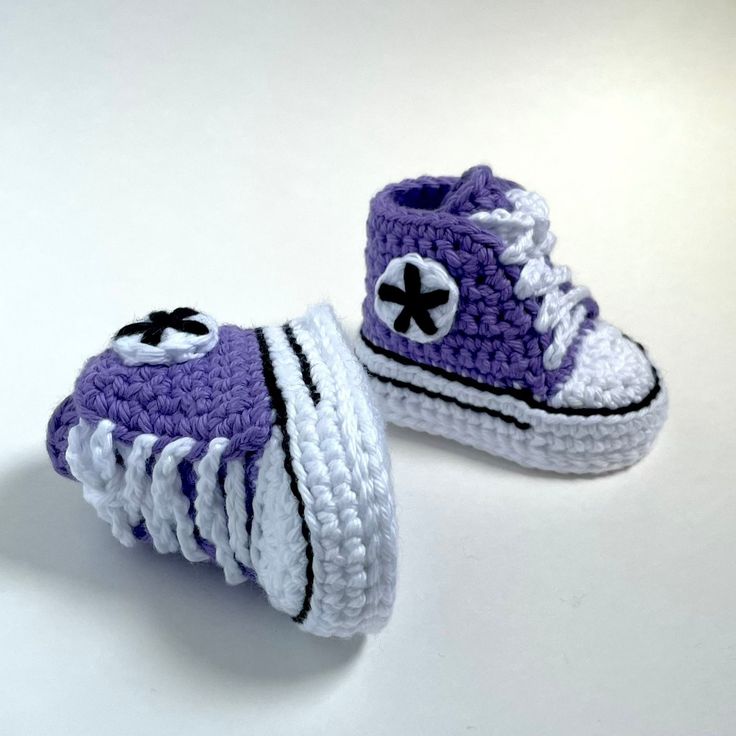 two crocheted shoes with black and white accents