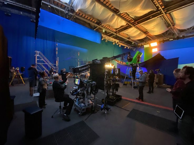 a group of people standing in front of a camera set up for a photo shoot