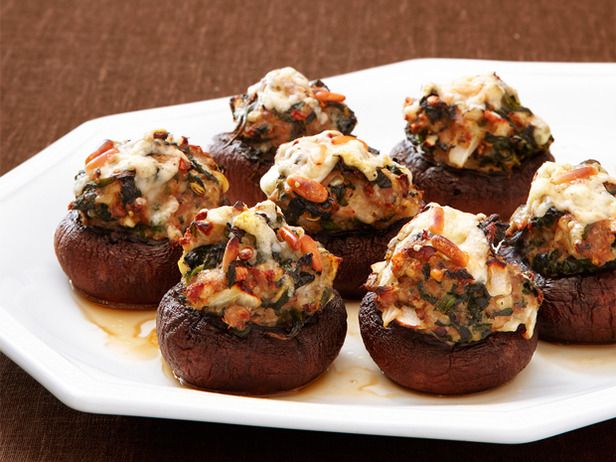 a white plate topped with stuffed mushrooms covered in sauce