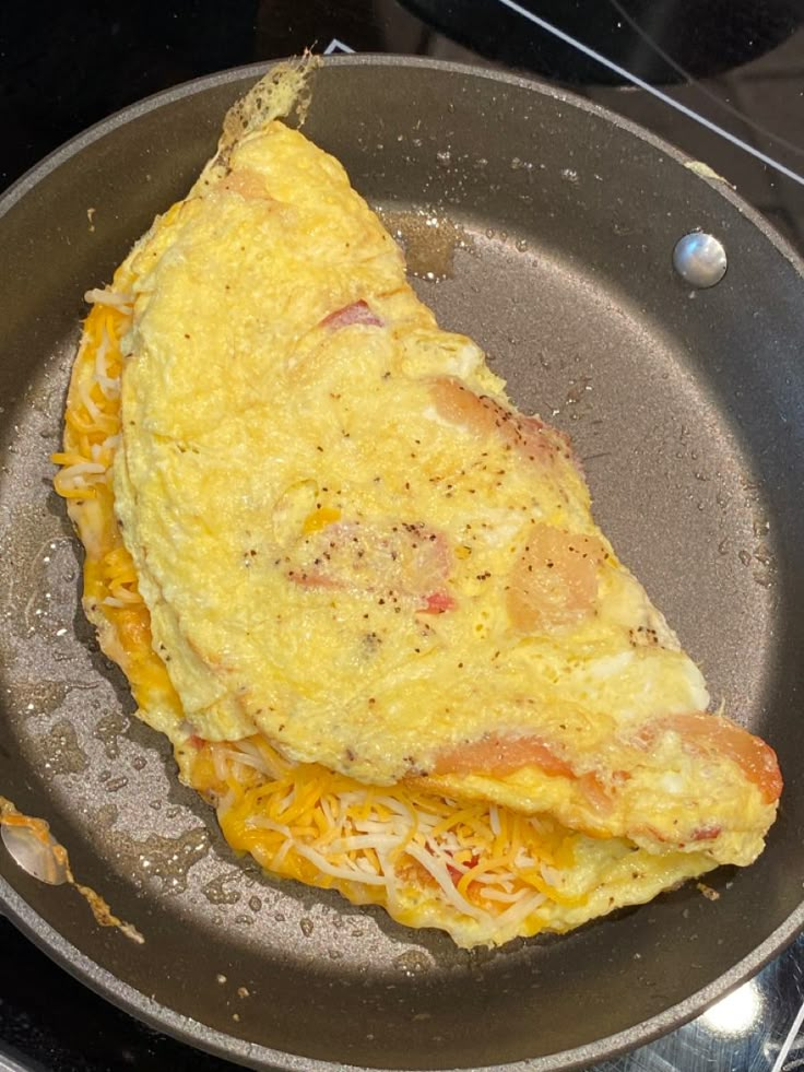 an omelet is being cooked in a frying pan