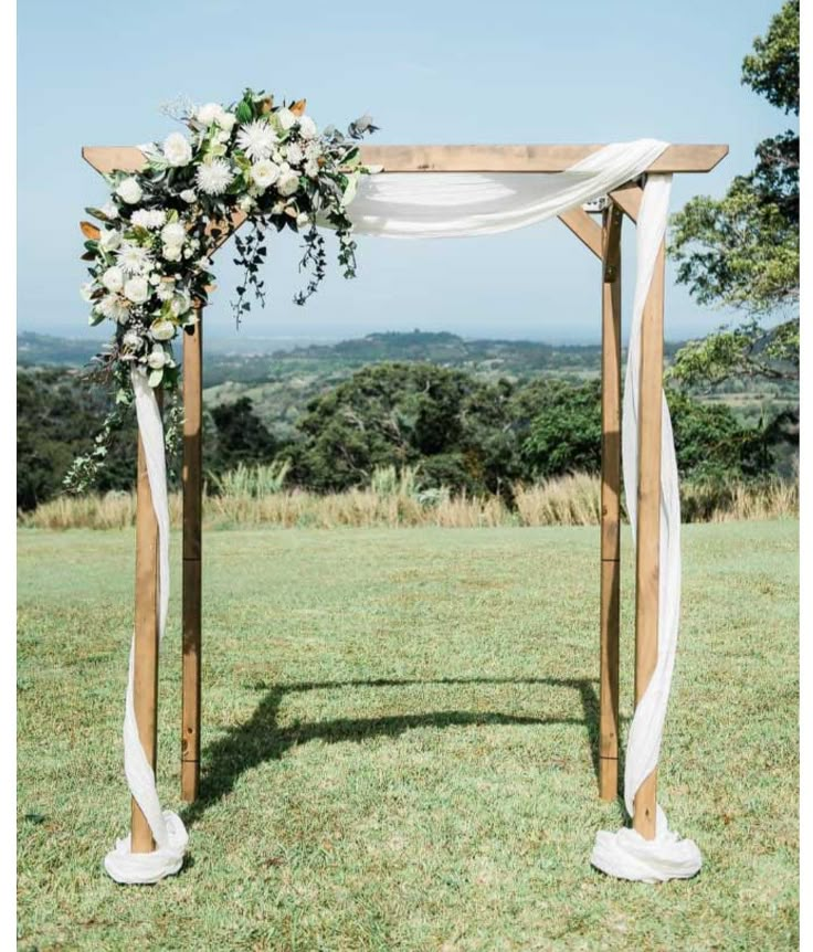 an outdoor wedding setup with white flowers and greenery