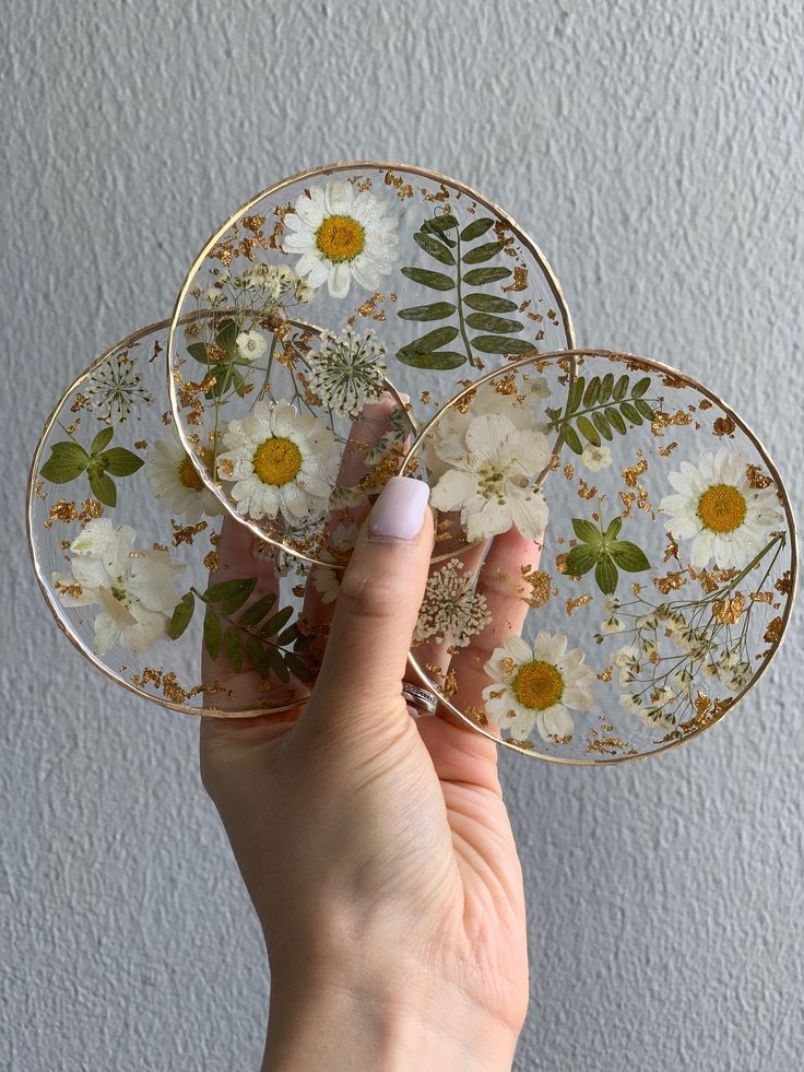 a person holding three plates with flowers on them