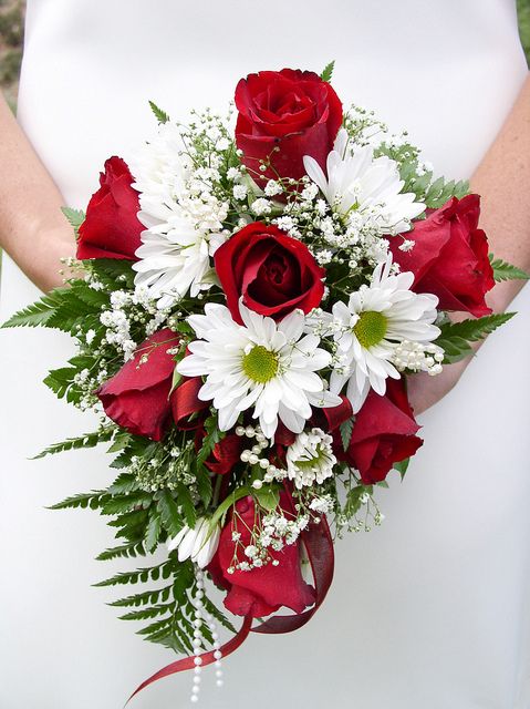 a bridal bouquet with red roses and white daisies