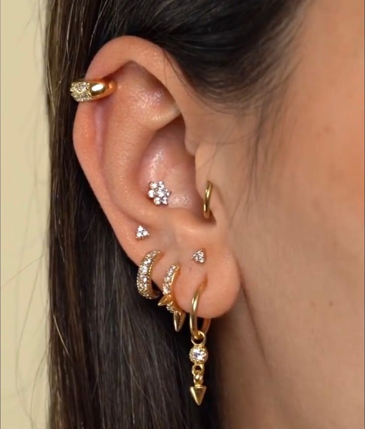 a close up of a person's ear with three different piercings on it