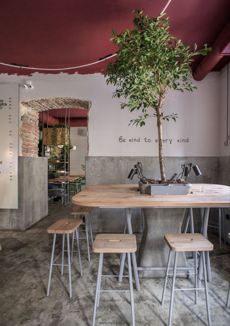 a table with four stools and a potted tree in the middle of it