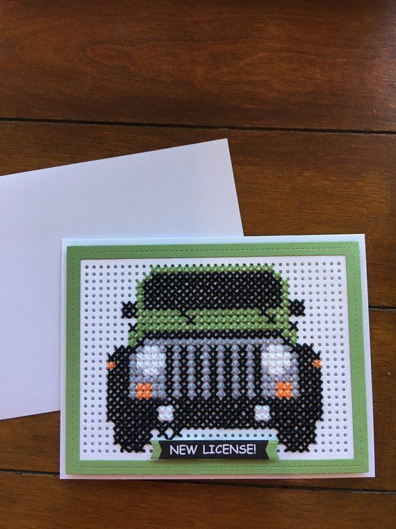 a cross stitch card with a green jeep on the front and white envelope in the back