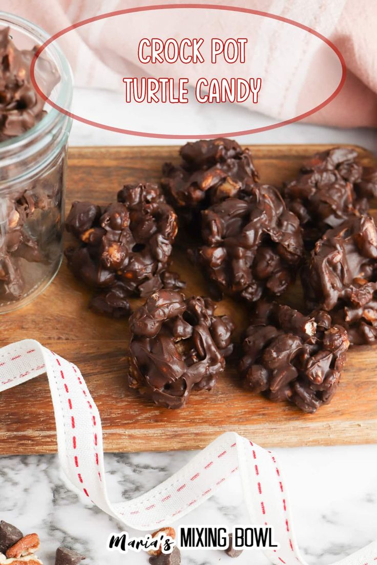 chocolate crock pot turtle candy on a wooden cutting board with ribbon and glass jar