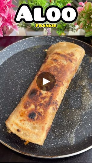 a pancake on a black plate with flowers in the background and text aloo