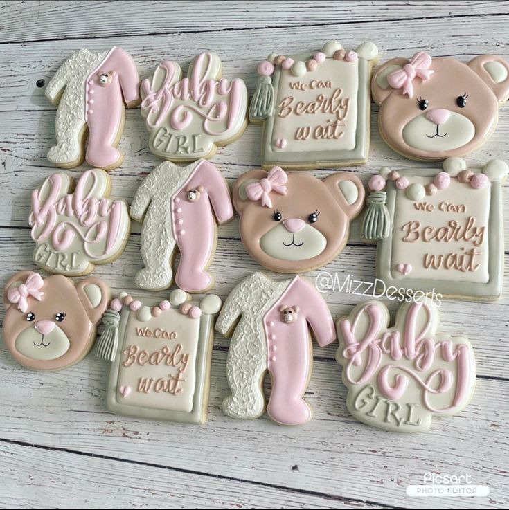 baby shower cookies decorated with teddy bears and pink icing on a white wooden table