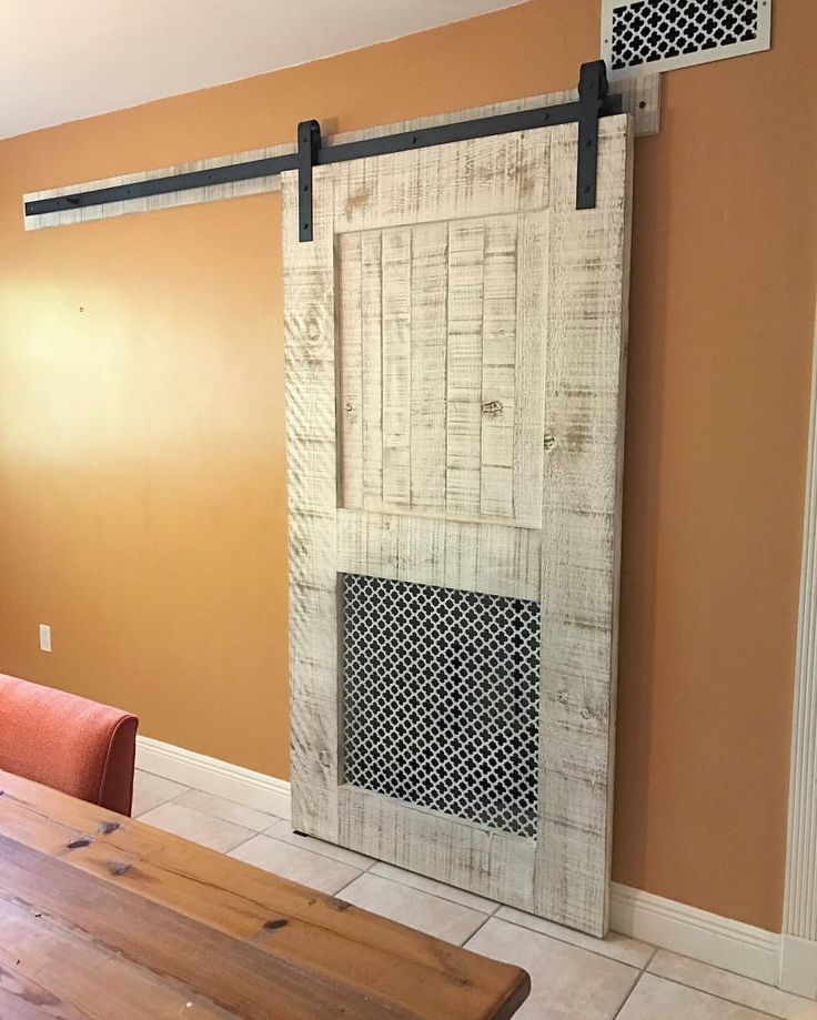 a wooden table sitting next to a sliding door in a room with an orange wall