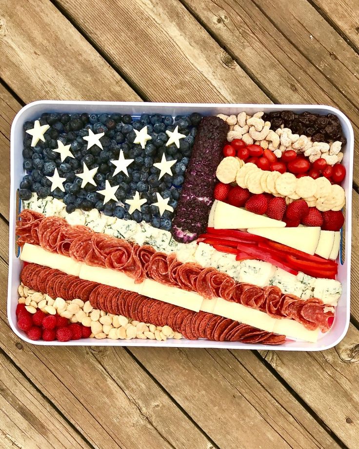 an american flag made out of fruit and nuts in a container on a wooden table