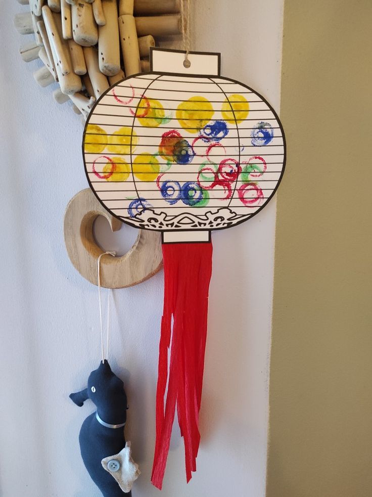 a wind chime hanging from the side of a wall next to a toy whale