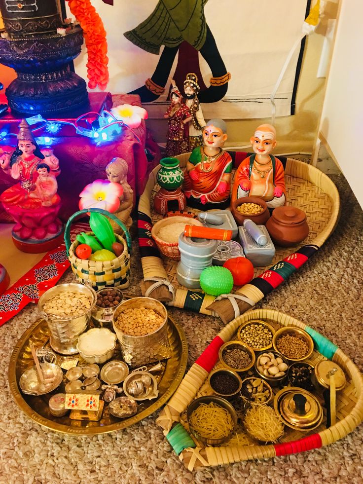 an assortment of items displayed on trays in front of a statue and other decorations