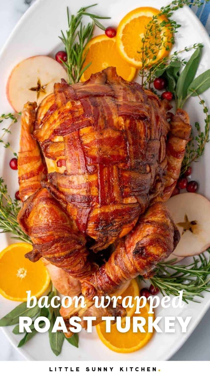 bacon wrapped roast turkey on a plate with oranges and rosemary