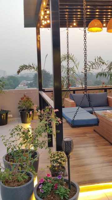 an outdoor living area with potted plants and lights