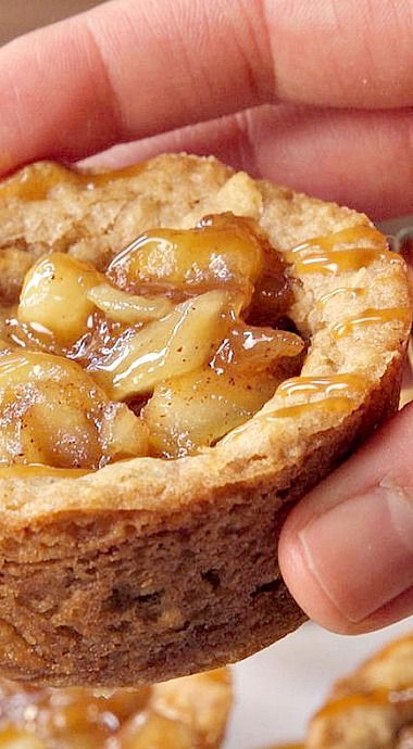 a hand holding a pastry with caramel toppings on it's crusty crust