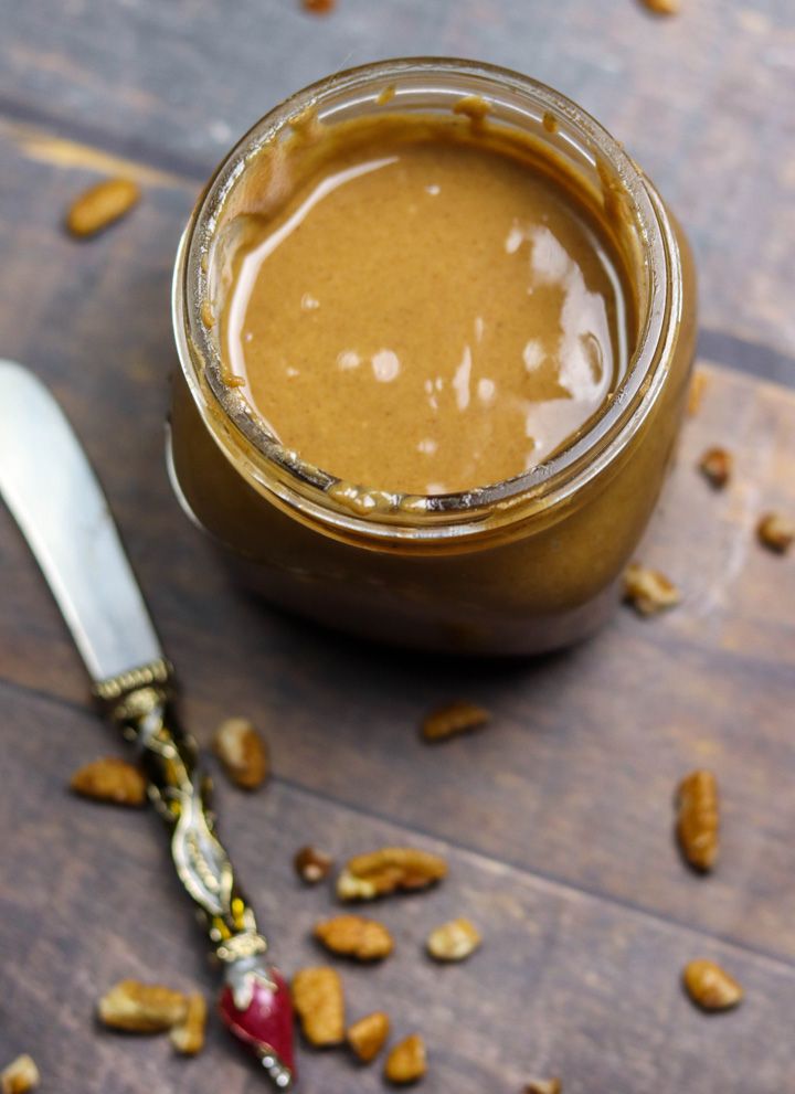 a jar filled with peanut butter next to a spoon