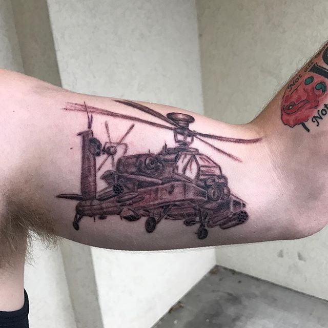 a man with a helicopter tattoo on his arm