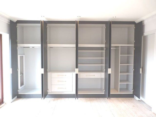 an empty room with shelves and drawers in the middle, all painted gray and white