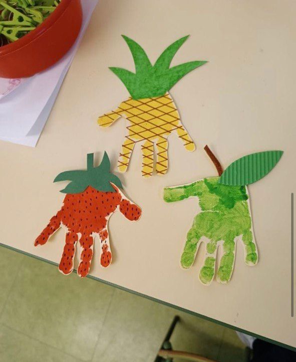 two handprints made to look like fruits and vegetables are sitting on a table