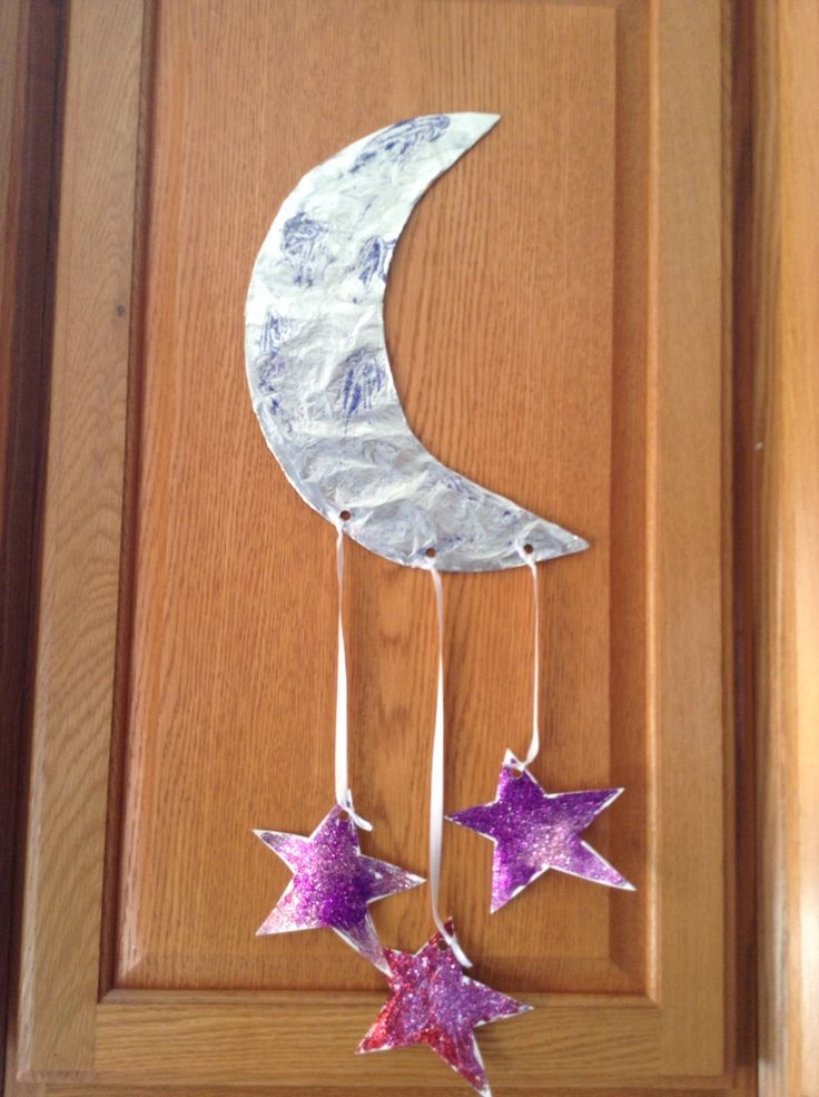 a paper moon and two stars hanging from a door handle with tin foil on it