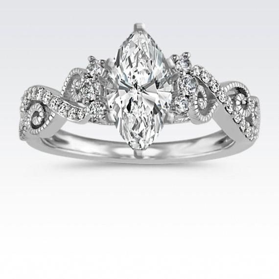 a white gold engagement ring with an oval cut diamond surrounded by small round brilliant diamonds