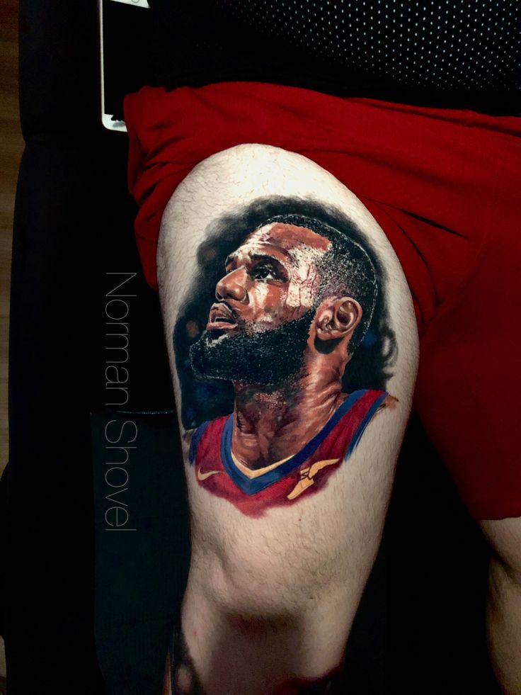 a man's leg with a tattoo on it that has a portrait of a basketball player