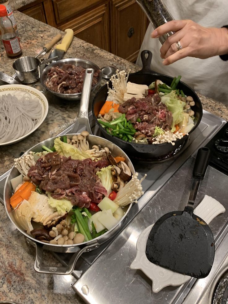 two pans filled with food sitting on top of a stove