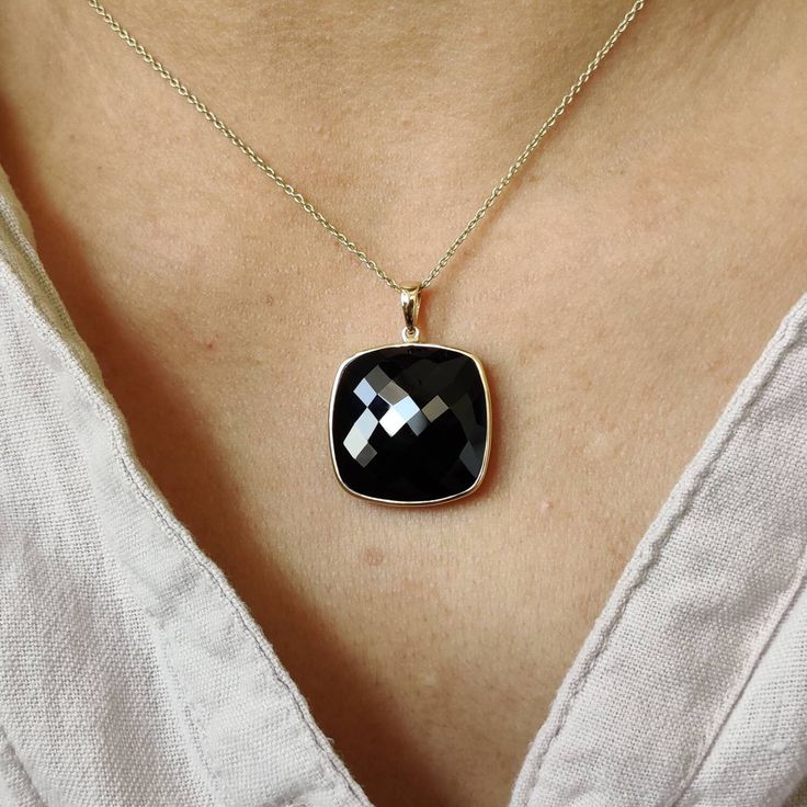 ITEM DESCRIPTION: >>The pendant is made from Solid 14K Yellow Gold. Gemstone used is absolutely natural and ethically sourced. >>Natural Black Onyx of cushion shape in bezel setting is studded on it with utmost precision. >>This is a minimalist design and is absolutely hassle-free and everyday jewelry. Gem: Black Onyx Gem size: 20x20 mm Gem weight: 19.71 carats Gold purity: 14K (58.33% approx.) Gold weight: 0.74 grams Gross weight: 4.68 grams The Gold purity is guaranteed and it comes with authe Fine Jewelry Onyx With Black Diamonds, Fine Jewelry With Black Diamonds And Onyx, Black Faceted Jewelry As A Gift, Black Faceted Jewelry For Gift, Black Pendant Jewelry For Anniversary, Black 14k Gold Jewelry With Bezel Setting, Black 14k Gold Pendant Jewelry, Black Jewelry With Bezel Setting For Gift, Onyx Jewelry With Black Enamel For Gifts