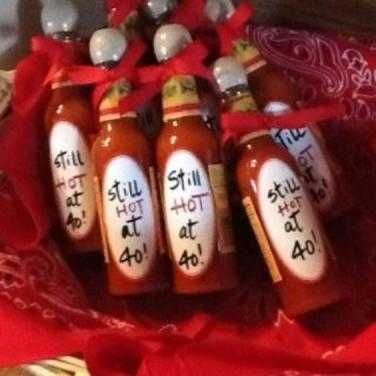 six hot sauce bottles with the words still hot at 40 written on them in black ink