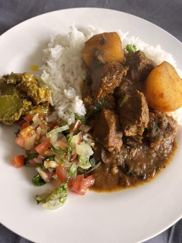 a white plate topped with meat, rice and veggies