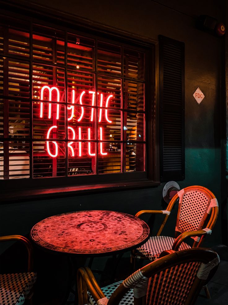 two chairs and a table in front of a window with the words music club on it