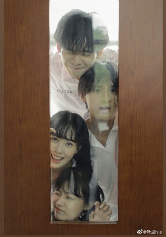 three young people are reflected in a mirror on the door way to an office building