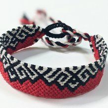 two red and black bracelets sitting on top of each other