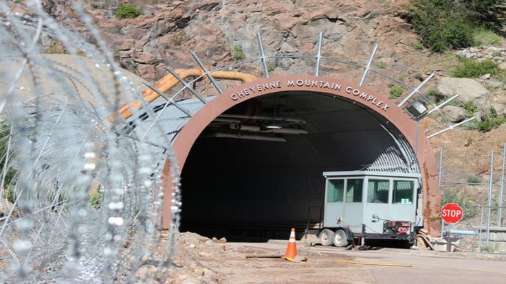 a truck is driving through a tunnel with mountains in the background