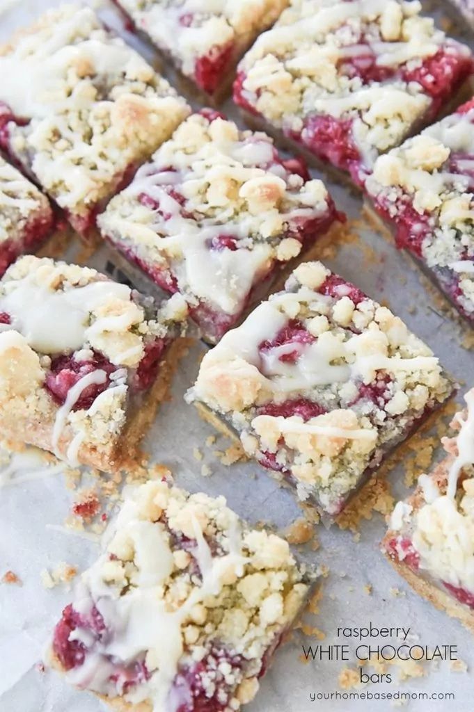 raspberry white chocolate crumb bars are cut into squares and stacked on top of each other