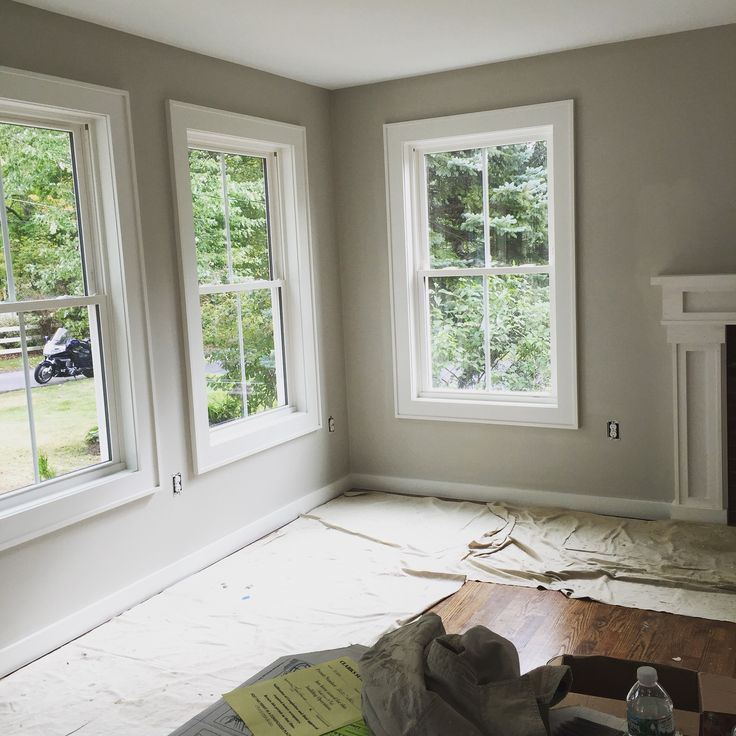 an empty room with three windows and some construction materials on the floor in front of them