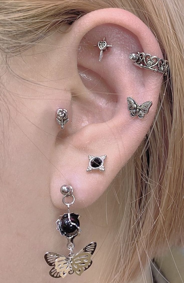 a close up of a person's ear with several different piercings on it