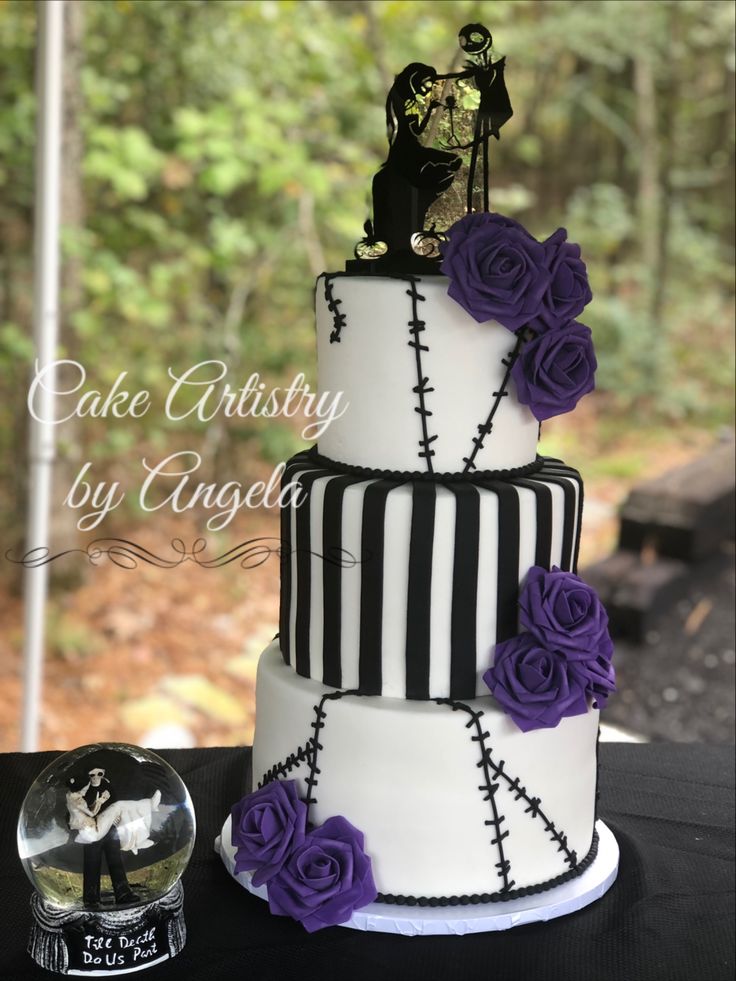 a three tiered cake decorated with purple roses and skeleton decorations is displayed on a table