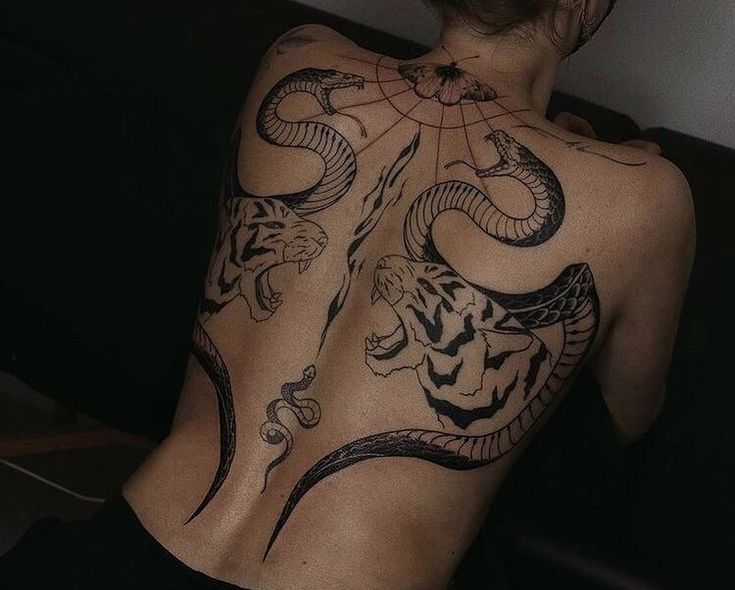 the back of a woman's body with tattoos on it