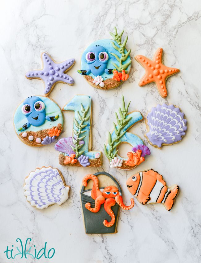 decorated cookies with sea animals and fish on a marble countertop, including one for the letter i