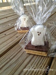 there are two cookies in the shape of ghostes on top of a wooden table