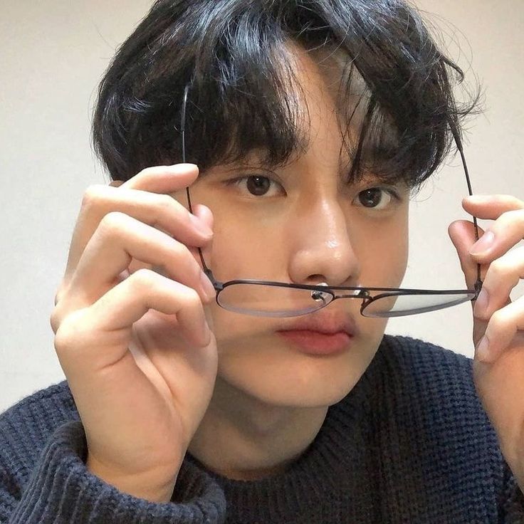 a young man is holding scissors to his nose